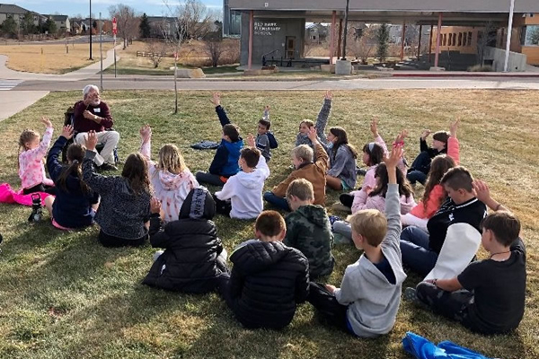 Children listen to storyteller outside Red Hawk School in Erie, Colorado.